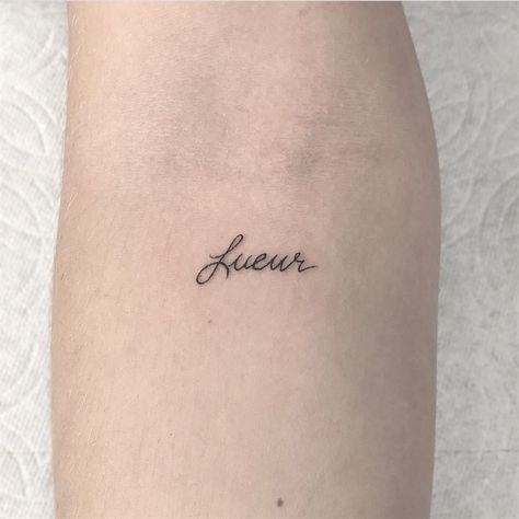 Word ‘Lueur’ which in French means ‘glow’ is inked in a minimalist font on the left inner arm French Word Tattoos, Small Words Tattoo, Glow Tattoo, Tattoo Words, Tiny Heart Tattoos, French Tattoo, Tatoo Inspiration, Meaningful Tattoo Quotes, Word Tattoo