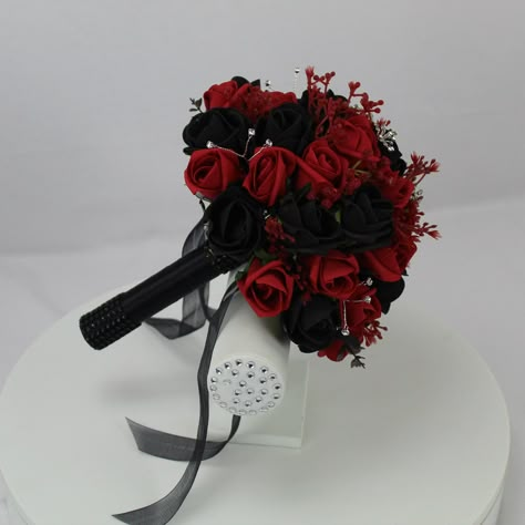 Realistic Artificial Black & Red wedding bouquet singles All bouquets have been made with quality flowers & our custom made diamante clusters & spays. The bouquet handles have been wrapped with satin/diamante ribbon and come with colour coordinated satin bows. These bouquets are available in 5 standard sizes & all buttonholes come with pin attached. We can also provide custom packages on request. Approximate sizes; Extra Large bouquet - 11 inches Large bridal bouquet - 9 inches Medium bridal bou Quince Bouquet Red And Black, Wedding Decorations Black And Red, Black And Red Wedding Theme Dress, Black Flowers Wedding Decor, Black And Red Quince Theme, Black And Red Flower Bouquets, Black And Red Roses Bouquet, Black And Red Wedding Bouquet, Red And Black Theme Wedding