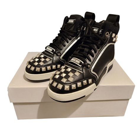 Elevate your street style with these sleek MOSCHINO Streetball Sneakers. Crafted in Italy from premium leather, these high-top sneakers feature a sturdy rubber sole and a comfortable leather insole. The black sneakers are adorned with stylish stud detailing, adding an edgy touch to your casual or sporty look. The sneakers are designed for men with a US shoe size of 11 and an EU shoe size of 44. The sneakers are perfect for any occasion, whether you're dressing up for work or hitting the gym. The sneakers are part of the Moschino product line and are ideal for all seasons, including winter, summer, fall, and spring. The sneakers are also customizable with a lace-up closure, making them a perfect addition to your shoe collection. Black Sneakers, Sporty Look, Summer Fall, Shoe Collection, Moschino, High Top, Top Sneakers, High Top Sneakers, Rubber Sole