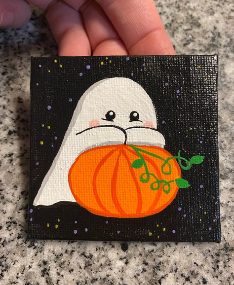 cute ghost on pumpkin, mini canvas painting. Hand drawn and painted on 2.5x2.5 canvas. Mini easel is included with painting. Each painting is made to order and may vary slightly. Sprayed with a glossy sealant. Mini Canvas Step By Step, What To Paint On Tiny Canvas, Halloween Ghost Painting Ideas, Ghost Holding Pumpkin Painting, Fall Art Painting Canvases, Easy Painting Ideas For Pumpkins, Canvas Fall Ideas Painting, Ghost And Pumpkin Painting, Pumpkin Wood Painting