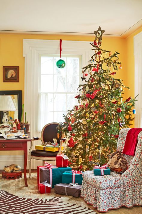 This vibrant, full Christmas tree acts as the pièce de résistance in the living room of Christopher Spitzmiller’s Hudson Valley getaway. The tree ornaments by Wendy Addison, John Derian, and Creel and Gow pop against bright yellow walls. The Parish-Hadley slipper chair is upholstered in a Bennison Fabrics print. The wall paint color is Sweet Butter by Benjamin Moore. Chic Christmas Tree, Vintage Scandinavian Furniture, Christopher Spitzmiller, Quotes Sweet, Holiday House Tours, Christmas Tree Decorating Ideas, Tree Decorating Ideas, Silly Quotes, Christmas Tree Decorating