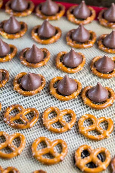 M&M Pretzel Kisses: a pretzel, a Hershey kiss, and a fun colored M&M -- so easy, but the bite-sized sweet and salty combination is irresistible. Match M&M colors to holidays for a fun school treat! Pretzel Hershey Kiss, Pretzel Hershey Kisses, Hershey Kisses Recipes, Pretzel Kisses, Pretzel Chocolate Bites, Pretzel Recipe, Pretzel Treats, Bunsen Burner, Easy Christmas Treats