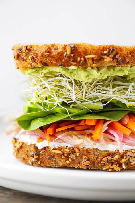 Work your way through layers and layers of bold flavors in this California veggie sandwich with pickled carrots, mashed avocado, lemony goat cheese spread, cucumbers, sprouts and baby spinach. This picnic favorite is a powerhouse of health and tastes like a sunny day in L.A! Bagel Sandwich Lunch, Sprouts Sandwich, Sprout Sandwich, Veggie Sandwich Recipes, Cucumber Goat Cheese, Goat Cheese Spread, Alfalfa Sprouts, Pickled Carrots, Superfood Salad