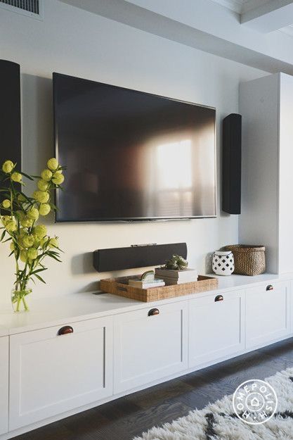 white built-in with shaker style cabinets under the wall mounted tv. This TV room has some serious surround sound! Decorate a media console with a tray and home decor. A tray is perfect for displaying accessories in because you can move it in a pinch AND use it to serve guests. Family Room Inspiration, Tv Cabinet Design, Flat Screen Tv, Tv Wall Decor, Living Room Tv Wall, Family Room Design, Living Room Storage, A Living Room, Lounge Room