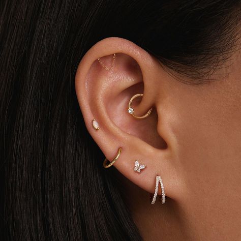 Discover trendy ear piercing ideas that range from classic lobes to edgy helix and daith piercings! Get inspired to mix and match styles for a personalized look. ✨ #EarPiercingIdeas #PiercingInspo #HelixPiercing #LobePiercing #DaithPiercing #PiercingStyle #Piercing #nosepiercing #bellybuttonpiercing #industrialpiercing #lippiercing #tonguepiercing #earpiercing #cartilagepiercing #spiderbitepiercing #multipleearpiercing #facialpiercing #hippiercing #earcuff #earjewelry #eargauge  #goldearrings #earplugs #diamondearrings #pearlearrings #earmuffs #silverearrings #hoopearrings #beadedearrings Yellow Gold Ear Styling, Ear Piercing Ideas Simple Classy, Tiny Tragus Piercing, Hanging Cartilage Piercing, Ear Party Piercings, Daith Piercing Hoop, Hidden Helix Earrings, Dainty Cartilage Piercing, Simple Daith Piercing