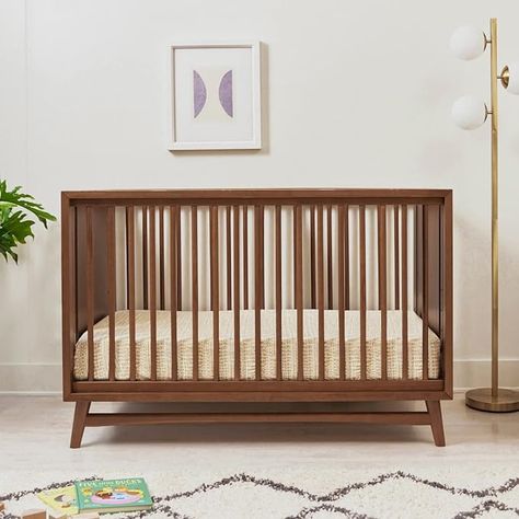 REFINED MID-CENTURY MODERN STYLE: Featuring a modern, clean silhouette and classic rounded spindles. Flared tapered legs add a playful touch to this sophisticated crib. 3-IN-1 CONVERTABILITY & ADJUSTABLE HEIGHT: The Peggy transitions from crib to toddler bed and daybed, with an included toddler bed conversion kit. The low profile design and 4 adjustable mattress positions make it easy to put a newborn to rest. Crib To Toddler Bed, 7 Drawer Dresser, Adjustable Mattress, Convertible Crib, Natural Walnut, Crib Mattress, Kids Nursery Decor, Nursery Furniture, Indoor Air Quality