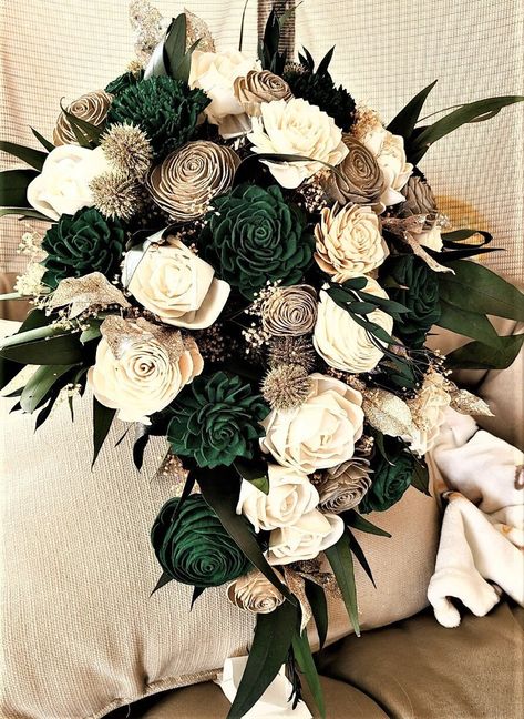 "This pretty cascade features wood flowers in a dark green and gold with preserved greenery.  This bouquet measures about 16 inches in \"height\" and 10-12 inches across (diameter). To purchase matching boutonnieres, look here: https://www.etsy.com/shop/mydinosaurdreams/?section_id=21264911 To purchase matching corsages, look here:  https://www.etsy.com/shop/mydinosaurdreams/?section_id=21264913 **Sola Flowers** *Sola flowers are hand-made from a soft wood (similar to balsa) and as such, each is Green Black Gold Wedding Bouquet, Emerald Green And Champagne Wedding Bouquet, Black Green And Gold Wedding Cake, Emerald And Beige Wedding, Emerald Green Bridal Bouquet, Green Wedding Flowers Bouquet, Emerald Gold And Black Wedding, Emerald Wedding Flowers, Emerald Wedding Bouquet