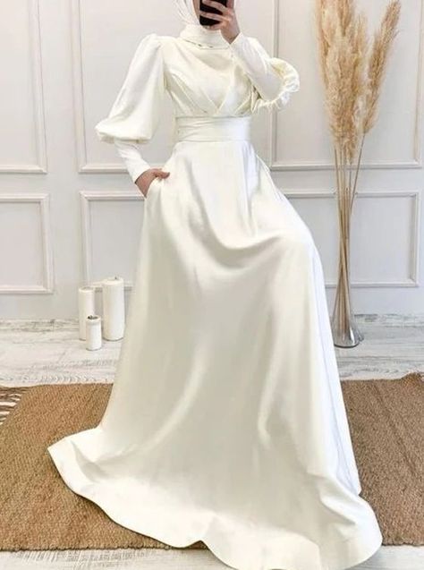 Make a regal and timeless statement in this modest Muslim Dubai long-sleeves bridal dress. Crafted from soft satin, this elegant A-line silhouette features a high neck, long sleeves, natural waist, and court train. Pleats and pockets on the skirt add texture and style, while a zipper back closure provides a secure fit for all-day comfort. Hijabi Wedding Dress, Juliet Sleeve, Wedding Dresses Muslim, Long Sleeve Bridal Dresses, Wedding Dress With Long Sleeves, Nikah Dress, Estilo Hijab, Hijab Wedding Dresses, Nikkah Dress