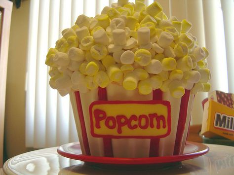 I made this Popcorn Cake for a movie night. Bucket was molded from a giant cupcake pan using Candy Melts.  Sign is also Candy Melts. Popcorn is mini marshmallows, cut up and reassembled to resemble kernels, some tinted yellow.   Inside: Butter pound cake with alternating layers of dulce de leche, dulce de leche whipped cream, vanilla pudding and spackled together with caramel-brown butter buttercream frosting. Big Cupcake Cake, Movie Night Cake, Big Top Cupcake, Giant Cupcake Mould, Giant Cupcake Ideas, Giant Cupcake Cake, Jumbo Cupcake, Giant Cupcake Cakes, Popcorn Cake