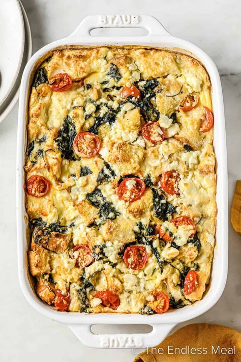 This spinach tomato strata is a healthier take on traditional strata, but you'd never know it. It's crusty bread layered with a generous amount of spinach, cherry tomatoes, and feta cheese and then baked until golden. It's easy to make and assemble ahead of time, and it's ready in just over an hour! #theendlessmeal #strata #tomatospinachstrata #breakfast #breakfaststrata #brunch #bread #eggs #christmasbrunch #mothersday #breakfastrecipe Breakfast Strata Recipes, Spinach Strata Recipe, Cherry Tomatoes And Feta Cheese, Tomato Egg Bake, Spinach Strata, Strata Recipes Breakfast, Tomatoes And Feta Cheese, Vegan Breakfast Casserole, Greek Breakfast