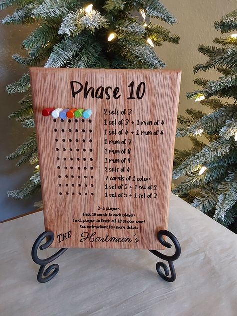 Phase 10 game board. Comes with pegs with different color top. Can be personalized. These are made when ordered. Please comment what you would like to say in the personalized tab. Thanks for looking! These are made from 3/4 inch thick Oak. Game Night Score Board Diy, Wooden Adult Games, Homemade Games, Glowforge Game Boards, Laser Engraved Board Games, Diy Wooden Games, Woodworking Christmas Gifts, Combination Wood Board Game, Homemade Board Games