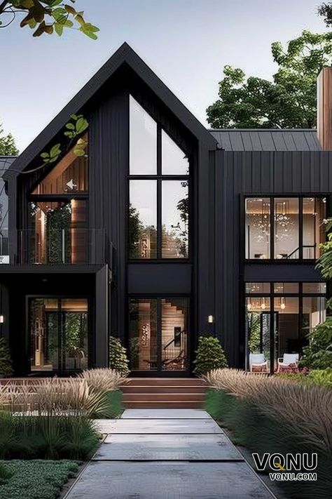 A modern black house with striking architectural design, large glass windows, and a beautifully landscaped entrance. Transitional Modern Home Exterior, Modern Home Outside Design, Black And White Modern House, Black Contemporary House, Black Lake House, Dark Modern House Exterior, Transitional Exterior Home Design, Modern Container House Design, Modern Transitional Exterior