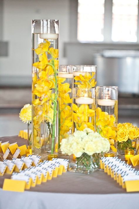 This is a pretty idea for tables- not sure if it goes either but love the yellow orchids   Yellow orchids + white floating candles in tall glass cylinders. Pale Yellow Weddings, Yellow Centerpieces, Flower Petal Confetti, Yellow Wedding Colors, Yellow Wedding Bouquet, Yellow Wedding Inspiration, Yellow Wedding Dress, Yellow Wedding Theme, Flowers And Candles