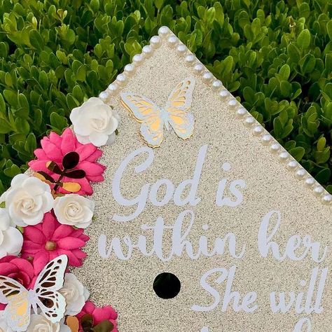 Grad Cap Artist | Adamaris on Instagram: "“God is within her she will not fail”   Description: gold glitter topper with pearl border. White and hot pink flowers on left and bottoms corner area of cap. Quote in white font on remaining space. White butterflies with gold backing spread around. Gold foil leaves in flowers. ______________  Follow me on Tik Tok @ advbellearts  ______________  BOOKING GRAD CAPS FOR JUNE 6th and ON 👉🏻 book through link in bio not DMS!!  ______________  #advbellecaps #gradcapideas #gradcapdesign #bibleversecap #classof2022" God Is Within Her She Will Not Fail Grad Caps, Butterfly Grad Cap, Senior Things, Pearl Border, Grad Cap Designs, White Butterflies, Grad Caps, Hot Pink Flowers, Book Flowers