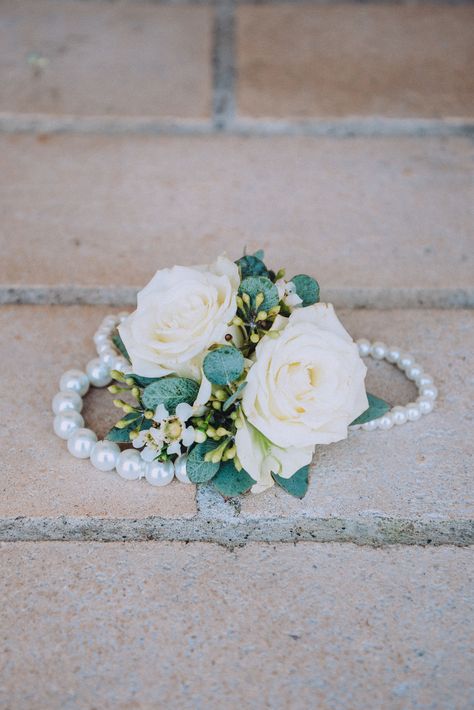 Elegant, dainty wrist corsage perfect for any mother of the groom or bride to wear on the wedding day. Designed with white spray roses, white waxflower, and a mix of greenery accented on a pearl 3 strand bracelet. Photo by - Taura Lynn Ryan Photography Venue - White Dove Barn #corsage #weddingcorsage #elegant #clean #simple #spray rose #weddingflowers #weddingflorist #tennesseeflorist #flowers Corsage Wedding Mother Wristlets Pearl Bracelets, Corsage Wedding Mother, White Waxflower, Mother Of The Bride Flowers, Mother Of Bride Corsage, Bride Corsage, Wedding Wrist Corsage, Prom Flowers Corsage, 3 Strand Bracelet