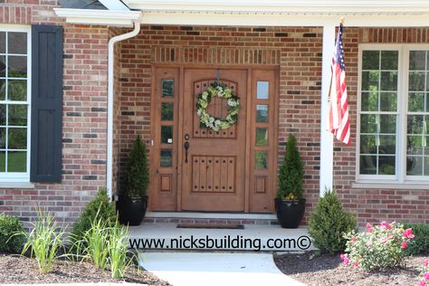 The Great American Entrance. Red Brick House with tan door. Door with reef. Single knotty alder door with side lites more wood doors at www.nicksbuilding.com Red Brick House With Wood Door, Red Brick House Wood Door, Wood Door On Brick House, Orange Brick Houses, Entry Door Colors, Brown Front Doors, Front Door Lighting, Orange Brick, Light Brick