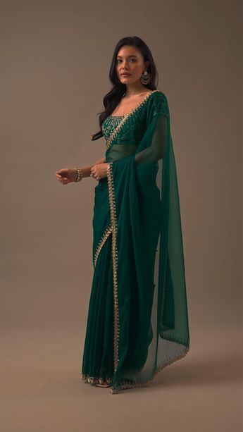 "Introducing our enchanting teal green plain organza saree, a celebration of simplicity and opulent detailing. This saree showcases a cutdana border that adds a touch of elegance. The unstitched blouse fabric features heavy cutdana work all over. EVENT - Perfect for evening parties. The saree comes with a matching unstitched blouse." Optical Illusion Dress, Cutdana Work, Saree Wearing Styles, Simple Saree Designs, Green Plain, Lehenga Designs Simple, Latest Model Blouse Designs, Fashionable Saree Blouse Designs, Fancy Sarees Party Wear