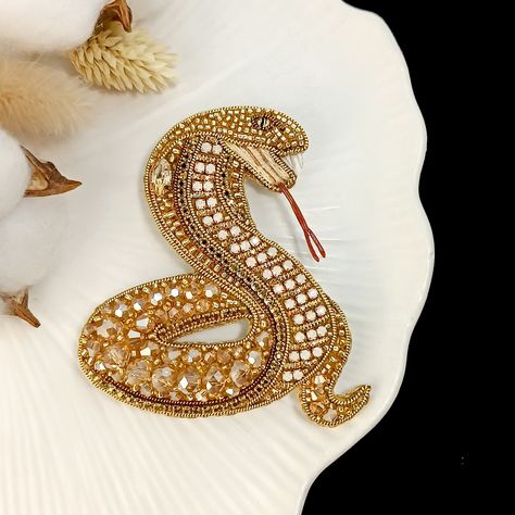 Add elegance and symbolism to your outfit with this stunning gold-tone snake brooch. Carefully crafted by hand, this unique piece of jewellery is not only a stylish accessory, but also a symbol of the year 2025.  A must-have addition to any jewellery collection. This cobra brooch is the perfect accessory for any occasion. Size: Length - 2 5/8 in (6.7 cm.) Width - 2 3/8 in (6 cm.) The product is packed in a box. It is convenient for a gift or for keeping a brooch. Snake Embroidery, Snake Brooch, Serpent Jewelry, Gold Work Embroidery, Snake Lovers, Brooch Handmade, Couture Embroidery, Belly Dance Costumes, Gold Work