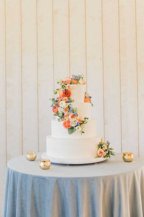 The wedding cake is such a perfect centerpiece for any wedding reception. We are obsessed with this four-tiered white cake covered in bright summer flowers. The roses and ranunculus are so beautiful! Wedding cake inspiration, summer wedding cake, wedding photography, Tasha Rose photography. May Wedding Cake Ideas, Wedding Cakes Real Flowers, Wedding Cake White With Flowers, Pastel Color Wedding Cake, Wedding Cake Floral Simple, Wedding Cake Designs Colorful, Wildflower Wedding Theme Cake, Real Flower Wedding Cake, Wedding Summer Flowers