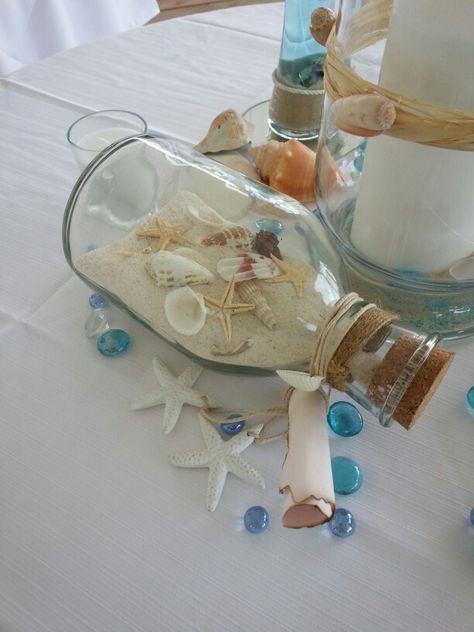 Beach wedding on a dime! Goodwill bottle with collected shells Diy Beach Wedding Decor, Seashell Themed Party, Beach Theme Wedding Reception Tables Centerpiece Ideas, Classy Beach Theme Party, Beach Themed Table Centerpieces, Simple Beach Wedding Ideas Decor, Ocean Themed Centerpieces, Beach Centerpieces Diy, Ocean Centerpieces