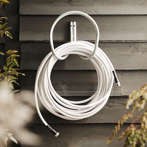 Choosing the right garden hose that isn't prone to leaks or kinks can make watering your lawn and garden a lot less frustrating. We put together a basic guide that will help you choose the perfect garden hose for your yard or garden. Patio Gardens, Outdoor Living Furniture, Hose Holder, Garden Hoses, Spring Easter Decor, White Gardens, Wooden Sculpture, Brass Fittings, Wooden Garden