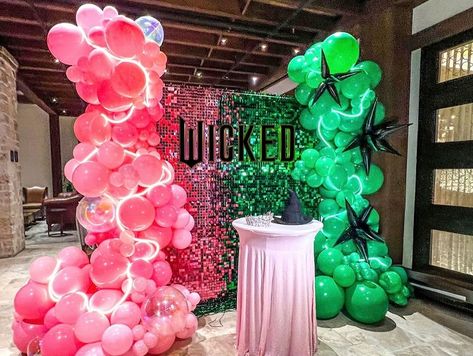 With this backdrop, you’re gonna be POPular! ✨ It feels like a piece of Oz landed right here 💚💗🔮🪄 DETAILS: •Ombre Green and Pink Shimmer Wall •Organic Columns •LED strip lights •Helium Balloons Glinda’s sparkling crown and Elphaba’s iconic black hat complete the look, bringing a touch of Oz where glamour meets mystery in perfect Wicked style! #wicked #wickedmovie #wickedthemusical #balloons #columns #marquee #green #pink #oz #mystery #magic #popular #party #movie #planning #nbc #arian... Shadow High Birthday Party, Wicked Movie Birthday Party, Wicked Wedding Theme, Wicked Musical Themed Party, Wicked Party Theme Ideas, Wicked Birthday Party Favors, Wicked Theme Birthday Party, Wicked Themed Party Decorations, Wicked Birthday Party Decorations