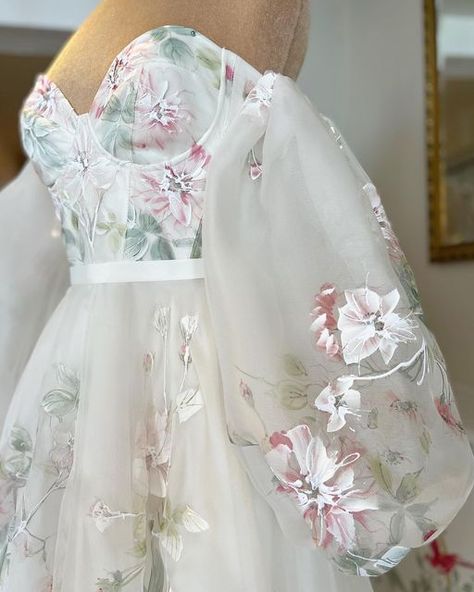 White Lace & Butterflies on Instagram: "a n g e l i n a 🌸 Possibly the most perfect dress we’ve ever seen for a quintessentially English country garden wedding! Her hand painted florals are simply divine, in a mixture of muted pinks, greens and whites, they cascade gently throughout her romantic floaty skirt. With a moulded cup bodice for modern flair and optional puff sleeves, she’s an absolute beauty and we just know you’re going to love her too. Brand new in by @savinlondon .⁣ .⁣ .⁣ Ivory Floral Wedding Dress, Corset Wedding Dress With Flowers, White Flower Wedding Dress, White Wedding Dress With Pink Flowers, White Dress With Pink Flowers, White Dress With Flowers, Wedding Dress With Flowers, Pink Wedding Dress With Floral Embroidery, Feminine Pink Embroidered Wedding Dress