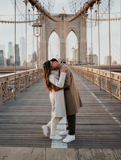 Man kissing woman on the cheek for their engagement photos taken in brooklyn at the brooklyn bridge in new york city New York Couple Outfit, Engagement New York, New York Couple Photography, New York Winter Engagement Photos, Brooklyn Bridge Picture Ideas Couple, Brooklyn Bridge Couple Photoshoot, Nyc Winter Couple Photos, Brooklyn Couple Photoshoot, Brooklyn Bridge Couple Pictures