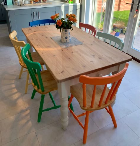 Colorful Painted Dining Chairs, Colored Chairs With Wood Table, Pop Of Color Kitchen Table, Different Color Chairs Dining Tables, Wooden Table With Different Chairs, Multi Coloured Dining Room Chairs, Colorful Kitchen Table And Chairs, Painted Pine Chairs, Upcycle Dinner Table