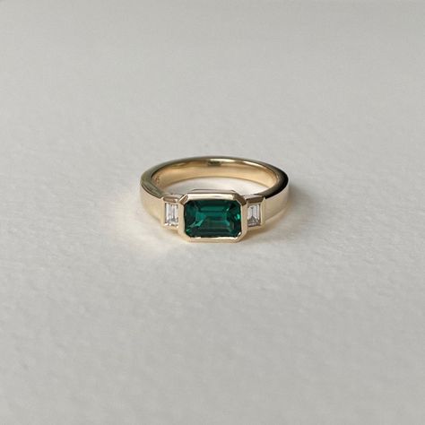 Solid 9ct yellow gold ring, set with 7x5mm emerald cut, hydrothermal emerald and two 3x2mm lab diamonds. Finished with a high polish. Ring is 6.5mm wide at top and 3mm wide at base. Engraved with the ve.co maker's mark, 've.' on the inside of the ring. Ring can be made in other precious metals and customised with different gemstones please email hello@vecojewellery.com for more information. Each piece is made to order, please allow 4 weeks for production. All jewellery is handmade so it is norma Emerald Ring Design, Trio Ring, Engagement Ring Inspiration, Gold Rings Fashion, Dream Engagement Rings, Jewelry Lookbook, Bling Rings, Dress Rings, Pretty Rings