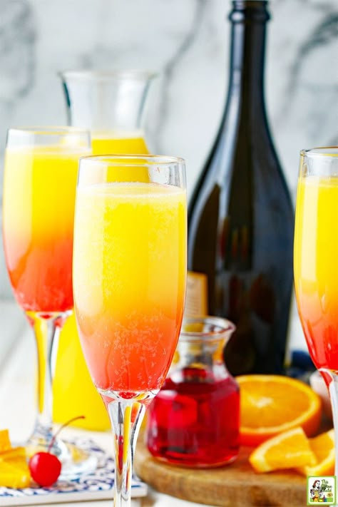 Sunrise Prosecco Mimosas served in fluter champagne glasses. With a bottle of sparkling wine in the background. Mimosa Recipe Easy, Prosecco And Orange Juice, Cranberry Mimosa Recipe, Prosecco Mimosa, Best Mimosa Recipe, Holiday Drinks Christmas, Mimosa Drink, Festive Holiday Drinks, Creamy Cocktails