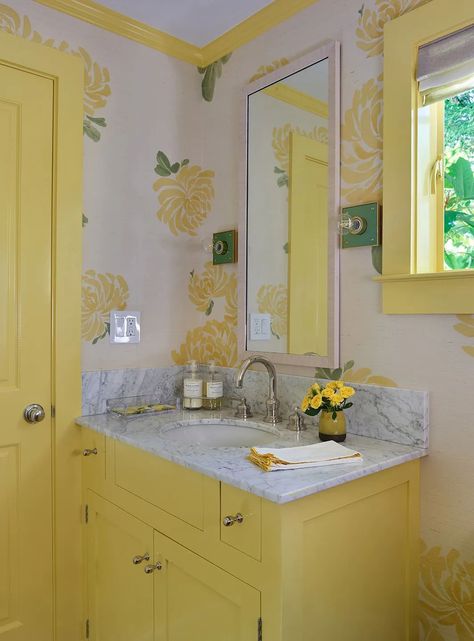 “For this project it was very natural to use yellow in the powder room [right off the kitchen],” she says. “I had no idea we’d be totally on-trend with Pantone’s color of the year—it just feels so organic.” The Hana Sisal wall covering is by Schumacher, and the Pop Sconces are from The Urban Electric Company. “I love their sconces…you can customize almost anything with them, so we chose a green backplate.” Yellow Bathroom Vanity, Yellow Vanity, Bathroom Colors Schemes, Chesterfield Style Sofa, Patterned Fabrics, Yellow Bathroom, Window Treatments Living Room, Yellow Living Room, Yellow Bathrooms