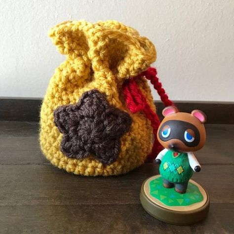 || Animal Crossing Inspired Dice Bag || .: For Animal Crossing fans of all ages .: Will make you appear wealthy.. .: Dont let Tom Nook see you carrying this >> c o l o r - Bags are gold with a brown star and red drawstring >> s i z e - Depth of 5.5 >> n o t e s - Item is Made to Order. Bell Bag Crochet, Rug Animal Crossing, Animal Crossing Bag, Animal Crossing Bell Bag, Bag Crochet Pattern Free, Diy Nintendo, Coin Purse Pattern, Bag Crochet Pattern, Crochet Geek