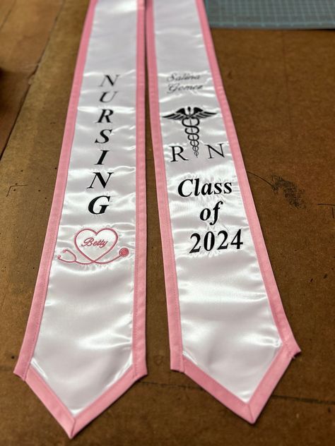 NURSING- RN Graduation Stole Stole is made just like picture. Your name will be added And your class year can be changed.  Right side: -Nursing with stethoscope heart with name inside (optional) Left side: -Your Name (script) -Class of 202X -Med symbol & RN or your Major   Use Pictures for reference, Will be just like picture. -Your Choice of Stole color -Your choice of edge color  -Your choice of thread color  Any additions will be an extra charge. -Message me for any particular color or any qu Grad Cap Ideas Nurse, Nursing Graduation Stole, Nursing Caps Graduation, Future Nurse Graduation Cap, Nursing School Graduation Cap, Nurse Pinning, Graduation Designs, Nursing School Supplies, Grad Stoles