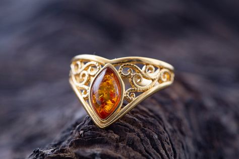 Art Gemelli present's lovely ring made of natural Baltic amber. It has been lovely set in sterling silver and covered by 14 CT gold layer. Cognac type of amber. Celtic heritage inspired design. Perfect for everyday use. Ideal gift.    Perfectly polished cognac Baltic amber set in 925 sterling silver setting and covered by 14 CT gold layer.    This ring comes with LIFETIME CRAFTWORK WARRANTY for your peace of mind. Gift wrap is also provided.    We source our amber from Baltic coast often looking Gold Amber Ring, Amber Diamond Ring, Amber And Gold Jewelry, Amber Ring Engagement, Amber Engagement Ring, Elegant Gold Jewelry, Amber Rings, Freeform Ring, Fashion Jewelry Rings