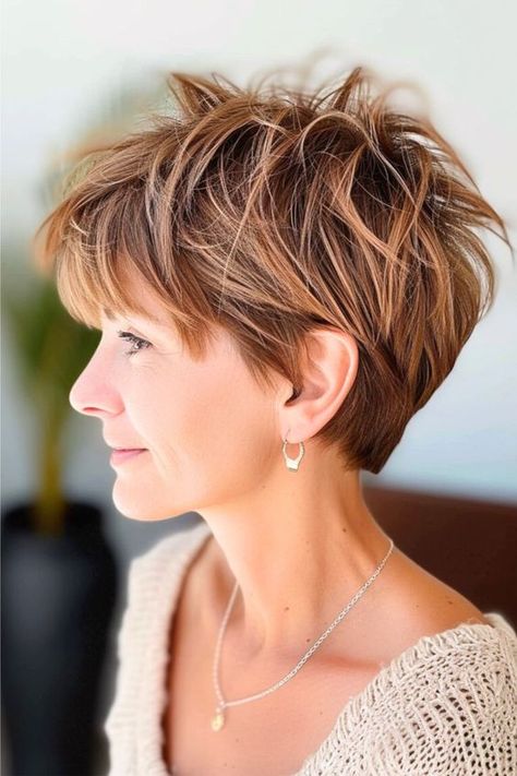 A layered pixie cut is all about playful textures and warm hues, giving off an energetic and fresh vibe. It's an excellent choice for fine hair or someone looking for a low-maintenance hairstyle that still packs a stylish punch. Click here to see more stunning wash and wear haircuts for women over 60. Haircuts For Older Women Over 60, Short Low Maintenance Haircut, Platinum Pixie Cut, Layered Pixie Cut, Messy Pixie, Pixie Cut With Undercut, Shoulder Length Layered, Modern Short Hairstyles, Lob Styling