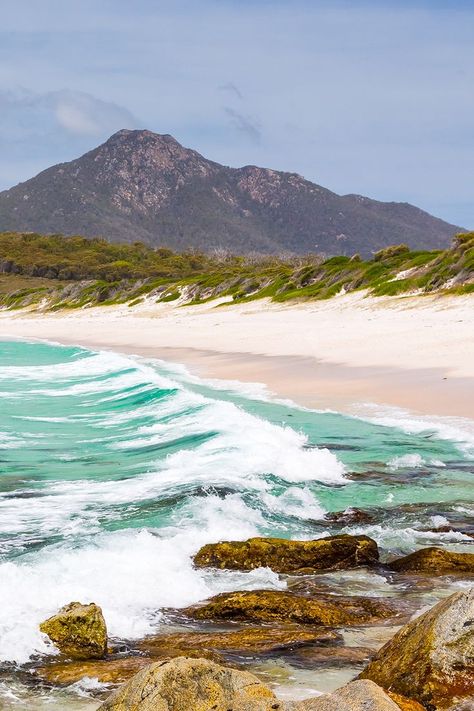 Gleaming white sands and aquamarine waters form the wide arc of Wineglass Bay, a breathtaking beach on the Freycinet Peninsula. This remote paradise is renowned for its beauty and is an idyllic spot to stop for a swim or a beach stroll. Accessible only via a bushland walking track or a scenic cruise, Wineglass Bay is an ideal daytrip within the pristine Freycinet National Park. 🌊 Start planning your trip with our travel guides. Australia Road Trip, Best Beaches In The World, Beaches In The World, Hawaiian Islands, Best Beaches, Tasmania, Plan Your Trip, Us Travel, Day Trips