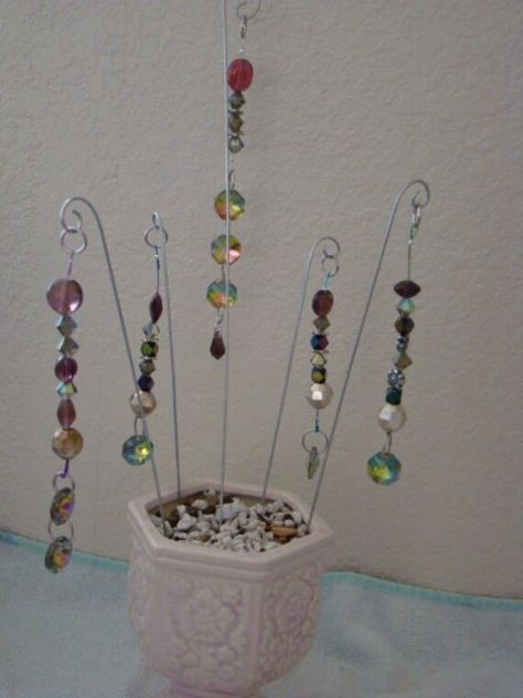 "Four different fairy garden stakes with beaded dangles and a large aurora borealis crystal at the bottom - your choice. Style A - has 4 beads, 2 spacers, and three AB crystals at bottom for that extra bling. 6\" long on 11 1/2\" stake. Style B - has 7 beads and two AB crystals at bottom. 5\" long on 8\" stake. Style C - has 8 beads and one AB crystal at bottom. About 5\" long on 8\" stake. Style D - has 6 beads, 2 spacers, and one AB crystal at bottom. 4\" long on a 7\" stake. Style E - has 6 b Beaded Garden Stakes Diy, Garden Stakes Diy Yard Art, Beaded Plant Stakes, Beaded Garden Stakes, Fairy Garden Stakes, Garden Sticks, Plant Pokes, Plant Stick, Plant Sticks