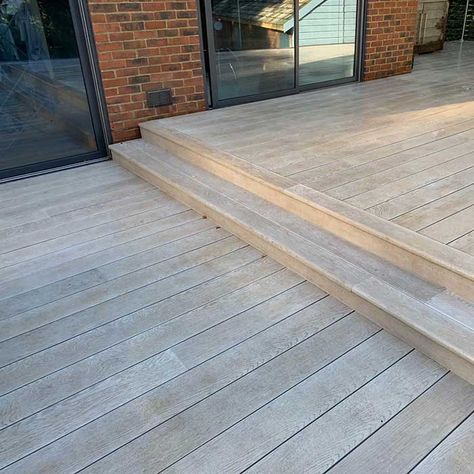 Smoked Oak Millboard Decking with cedar trellis and glass balustrade - Dorking | All on deck Decking Levels, Cosy Decking Ideas, Cream Decking, Stepped Decking Ideas, Deck Step, Oak Decking, Millboard Decking Ideas, Cedar Decking, Deck With Stairs