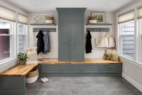 Mudroom/entryway, with mudroom cabinetry in a green-gray painted finish with a wood bench seating area, custom open shelving, and porcelain tile flooring. Mudroom With Sink And Bench, Wood Bench Seating, Entryway Cabinets, Mudroom Cabinetry, Porcelain Tile Flooring, Green Grey Paint, Mudroom Remodel, Kitchen Mudroom, Mudroom Storage