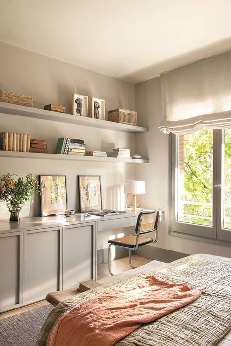 a cozy grey bedroom with a large bed and neutral bedding, grey cabinets and a built in desk, a cane chair and open shelves Cozy Grey Bedroom, Bedding Grey, Bedroom Office Combo, Spare Bedroom Office, Guest Bedroom Home Office, Bedroom Workspace, Guest Bedroom/office, Wallpaper Office, Home Office/guest Room