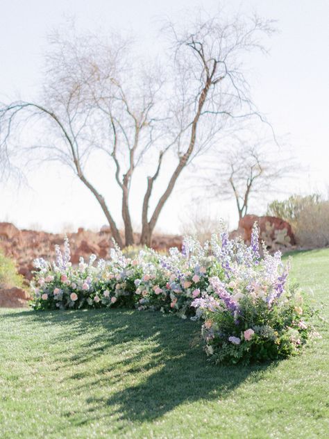 Grounded floral arch in colorful shades of purple, pink, peach, and blue. Ground Florals, Wooden Arch, Ceremony Flowers, Floral Arch, Lavender Blue, Pink Peach, Wedding Arch, Shades Of Purple, Styled Shoot