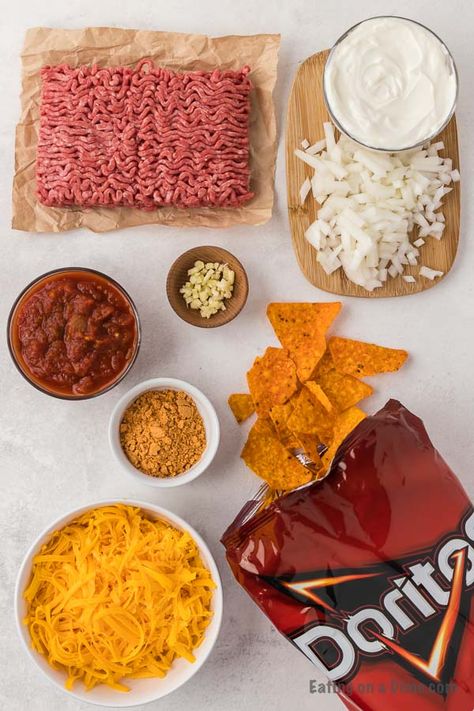 Easy Doritos Casserole Recipe - Eating on a Dime Layered Doritos Casserole, Dorito Taco Salad Casserole, Dorito Casserole Hamburger Crockpot, Recipes With Dorito Chips, Nacho Cheese Doritos Casserole, Easy Dorito Casserole Hamburger, Ground Beef Dorito Casserole, Taco Bake Casserole With Doritos, Dorito Taco Bake Casserole