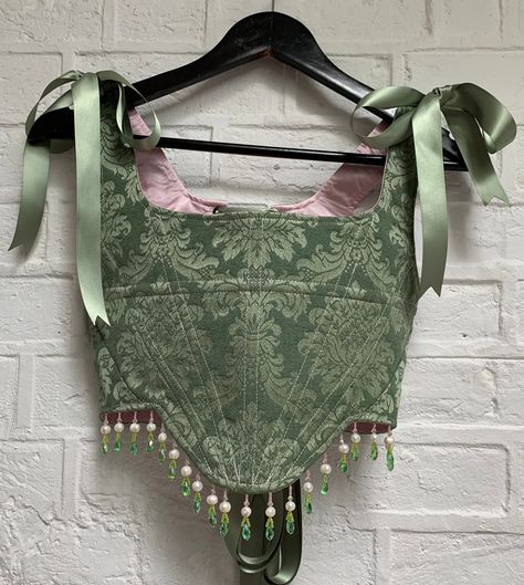 Made-to-order boned corset in sage green brocade. Embellished by hand around the hem with a combination of pink, green and freshwater pearl beading. Lace up back and tie straps fastened with satin ribbon. I would recommend sending me your measurements (last photo) so your piece can be bespoke to your size. I can also work from your trouser size, clothing size, bra size and height if necessary.  Please allow up to 4 weeks for your piece to be made and shipped. Every piece is made-to-order with lo Brocade Corset, Diy Corset, Ren Faire Outfits, Fair Outfits, Green Corset, Pearl Beading, Corset Outfit, Fairytale Fashion, Sewing Design