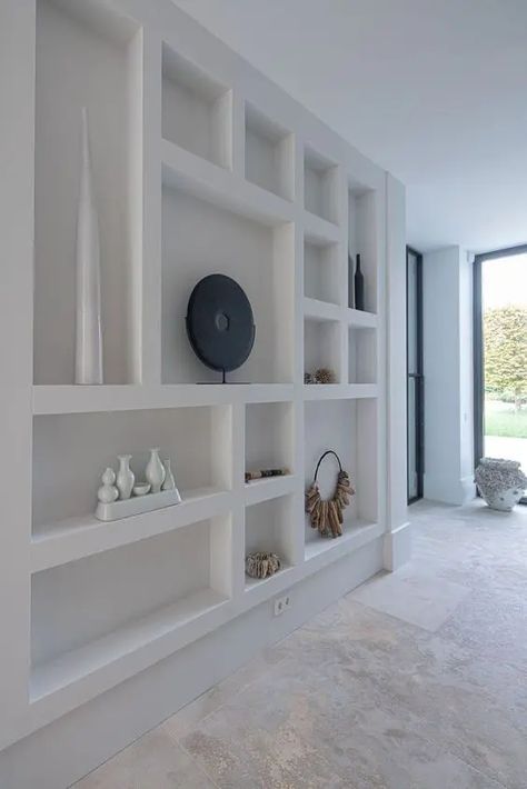 a whole wall taken by various niches that are used to display decor and add decorative value to the space How To Hang Shelves On Plaster Walls, Indented Wall Shelves, Large Wall Niche Ideas, Wall Niche Ideas Entryway, Niches Design Wall, Large Wall Niche, Wall Niches Ideas, Indented Wall, Modern Wall Niche