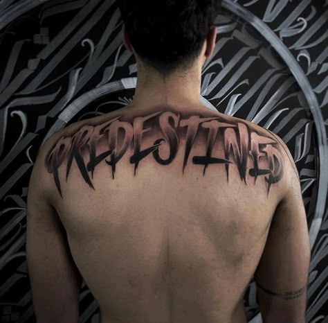 Back Writing Tattoos Men, Back Tattoo Men Writing, Top Of The Back Tattoos Men, Upper Back Word Tattoos Men, Last Name Across Back Tattoo Men, Back Tattoos For Guys Lettering, Back Lettering Tattoo, Lettering Back Tattoo, Words Down Leg Tattoo