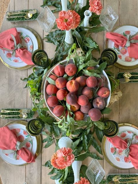 We're in the peak of peach season so it's the perfect time to create a unique tablescape with these beauties. I'm sharing some peach inspired tablescape ideas for summer entertaining with you. Fresh peaches, peach leaves, fresh flowers in orange and peach hues, thrifted plates, and vintage goblets were some of the things I used to create a unique summer table. I also shared a creative way to display your flatware and some tips for finding beautiful items for table decor on a budget. Peach Table Setting, Thrifted Plates, Creative Table Settings, Peach Soup, Peach Ideas, Peach Leaves, Potluck Dinner Party, Peach Sauce, Wedding Table Display