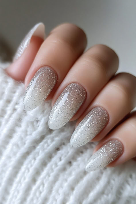 16 Pretty Christmas Glitter Nails To Try This Holiday Season White Nails With Glitter Almond Shape, White Sparkle Almond Nails, Glittery Holiday Nails, Christmas And Nye Nails, Christmas Nails Neutral Colors, White Sparkle Christmas Nails, Glittery Pedicure, White Ombre With Glitter, Mew Years Nails