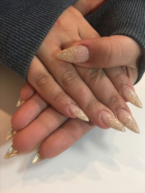 Long pointy soft gold nails Pointy Gold Nails, Gold Glitter Tips Acrylic Nails, Prom Nails With Gold Dress, Reflective Gold Glitter Nails, Ombré Gold Glitter Nails, Gold Foil Nail Designs Almond, Gold Flakes Almond Nails, Gold Ombre Nails Acrylic, Gold Minimal Nails