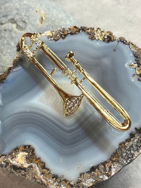 "Trombone pin, Trombone jewelry, Trombone charm, Orchestra Jewelry, Marching Band jewelry, Trombone Brooch, Brass Instruments Beautiful Gold Tone Trombone brooch with genuine crystals.  Perfect to add to Homecoming corsages or award banquet creations. A great gift for those involved in a Jazz Band, Marching Band or Orchestra! Trombone measures approximately: 1\" W  x 3 1/8\" H Trombone bin Marching Band Pin Orchestra Jewelry Trombone charm" Brass Instruments Aesthetic, Trombone Jewelry, Trombone Jokes, Trombone Aesthetic, Pretty Instruments, Gymnastics Jewelry, Brass Instrument, Band Jokes, Brass Instruments